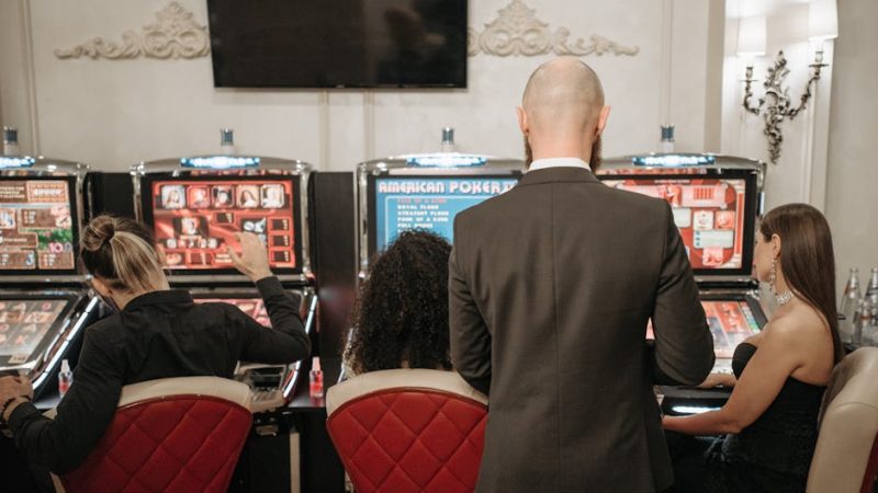 A group of adults engaged in playing slot machines inside a stylish casino setting.