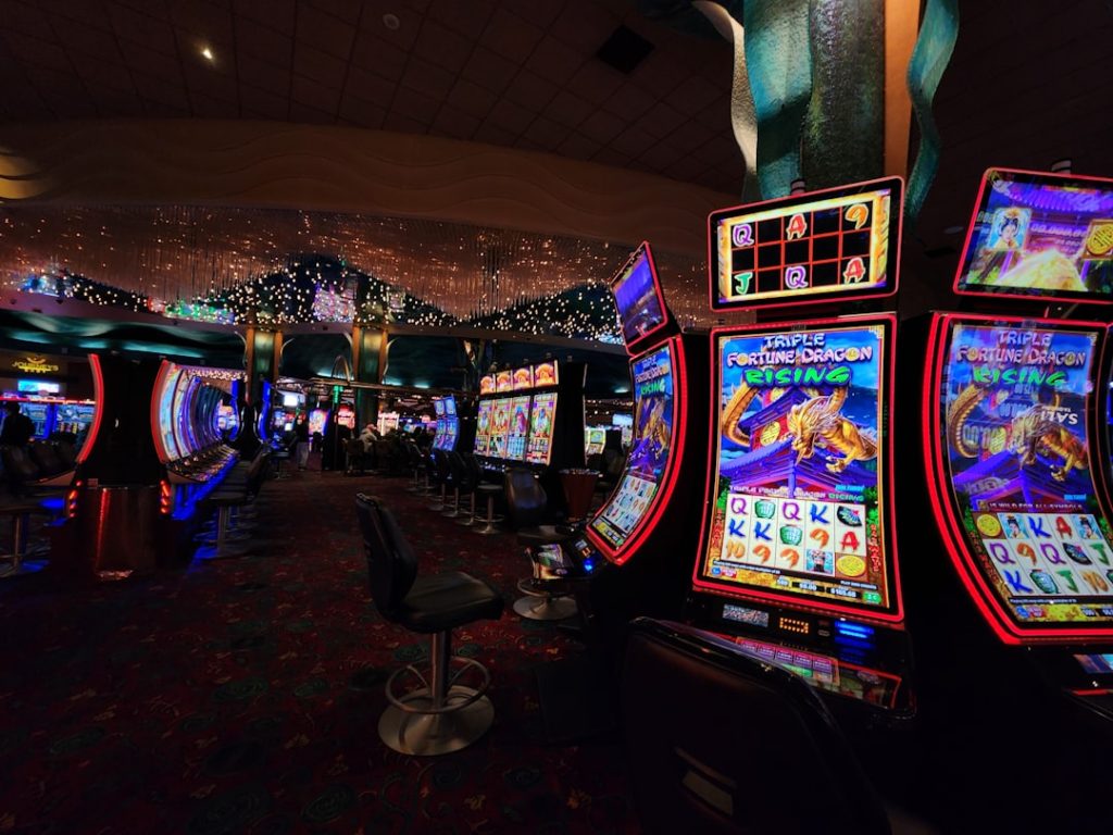 Soccer ball resting on a glowing casino slot machine screen in a dark neon-lit room
